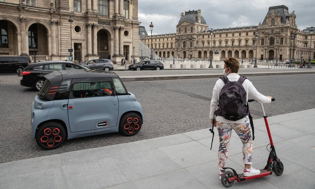 Na França, o elétrico Ami, da Citroen, é testado em frente ao Museu do Louvre, em Paris, em setembro. O veículo está na categoria quadriciclo e pode ser dirigido por jovens a partir de 14 anos. Foto: Abdulmonam Eassa / Getty Images