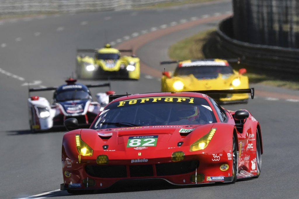 carro da Ferrari e outros três carros disputando corrida